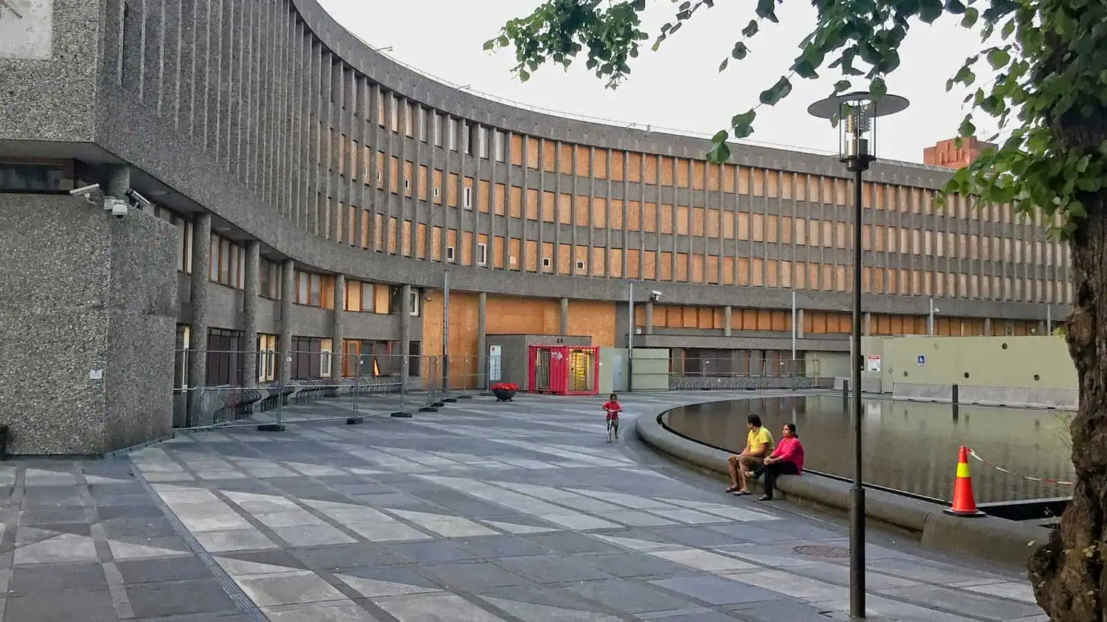 people sitting on concrete bench near brown concrete building during daytime